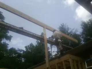 Carpenter setting a ridge beam over a new addition frame — Ice Dam Removal by Roofing Brothers in Middlebranch