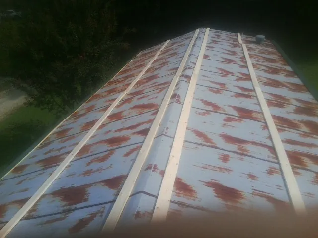 Rusted metal roof panels with new wood purlins before replacement — Storm Damage Roof Repair in Middlebranch by Roofing Brothers
