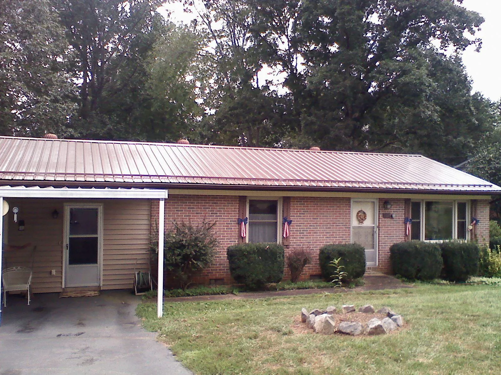 Bronze metal roof and carport on a brick ranch home — Roof Repair work by our crew in Middlebranch